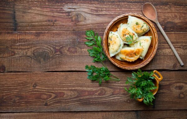 Na Camping Mazury serwowane są tradycyjne pierogi na drewnianym stole.