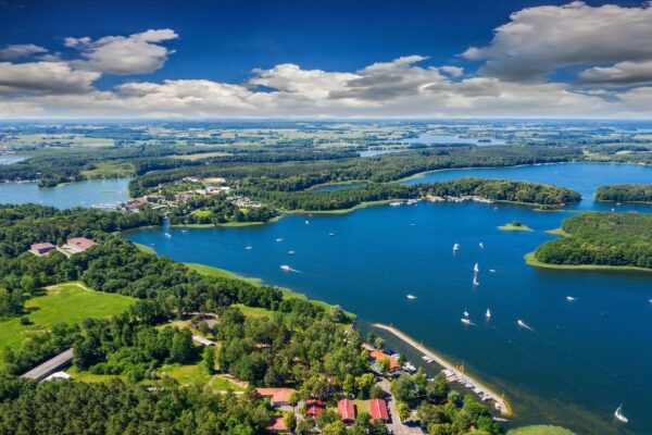 Widok z lotu ptaka na jeziora i Pole namiotowe Mazury w otoczeniu zielonych lasów.